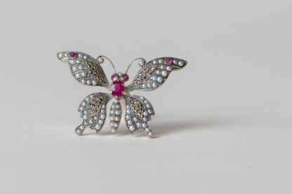 Broche en plata con perlas de agua dulce, marcasitas y rubíes.